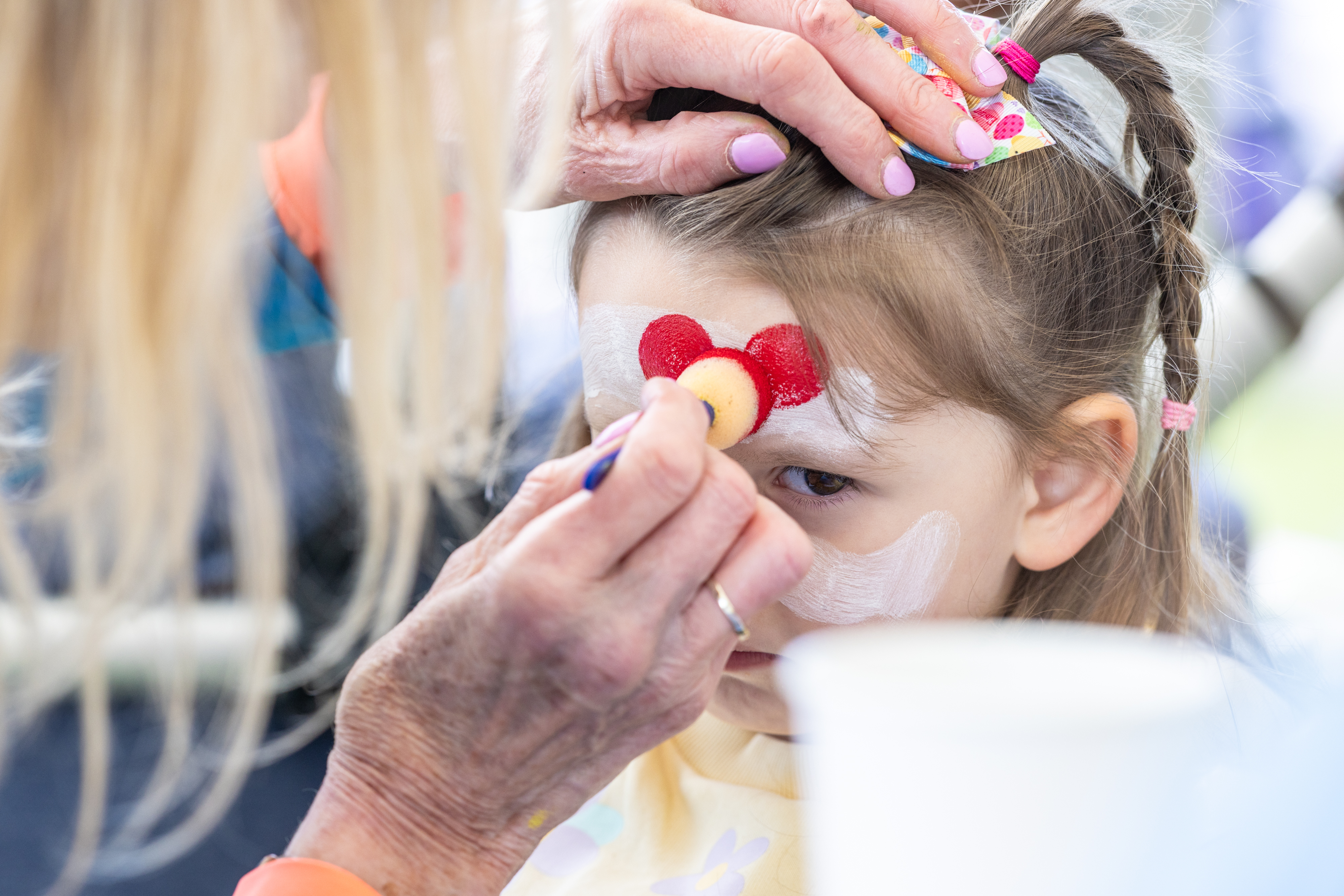Child getting their face painted. 